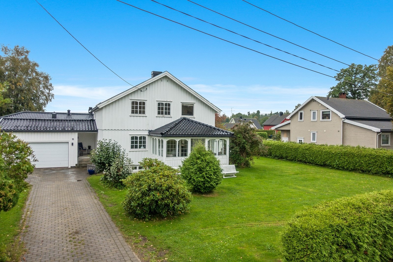 Innkjørsel med belegningsstein til nyere romslig tilbygget garasje. Galleribilde
