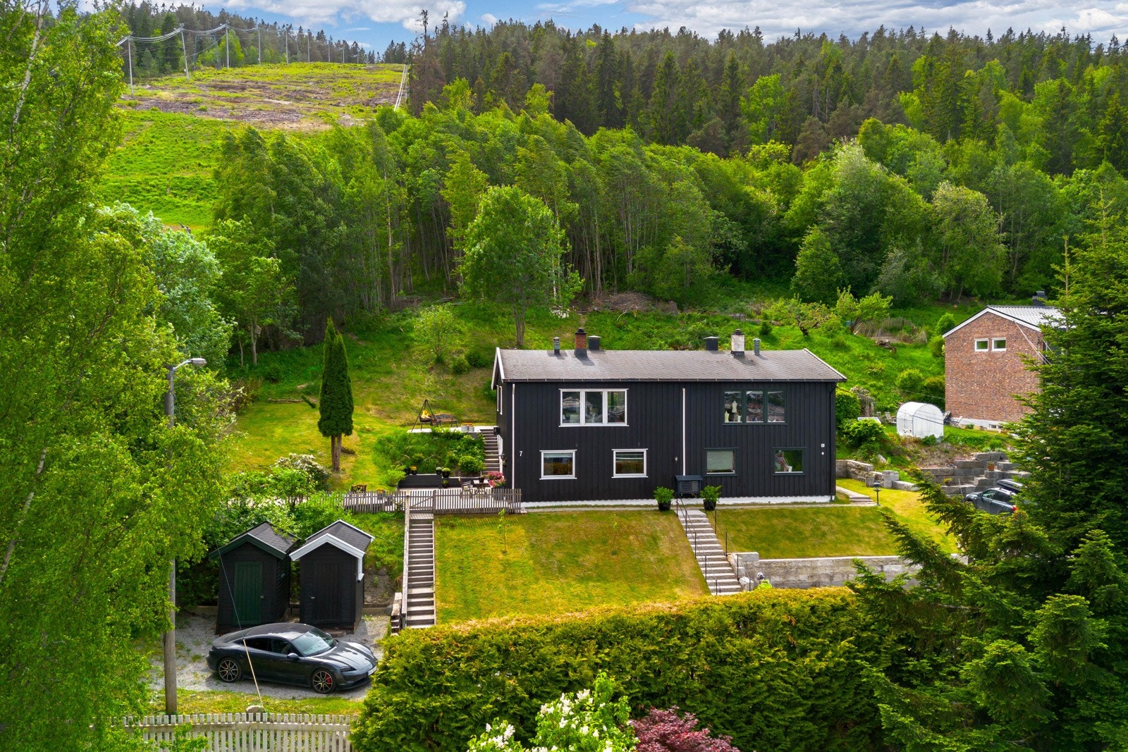 Pent opparbeidet hage med prydbusker, vintergrønt og romslig plen - perfekt for lek og avslapning. Galleribilde