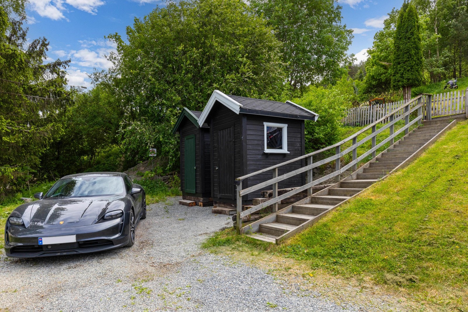 Gruslagt parkeringsplass og trapp opp til boligen Galleribilde