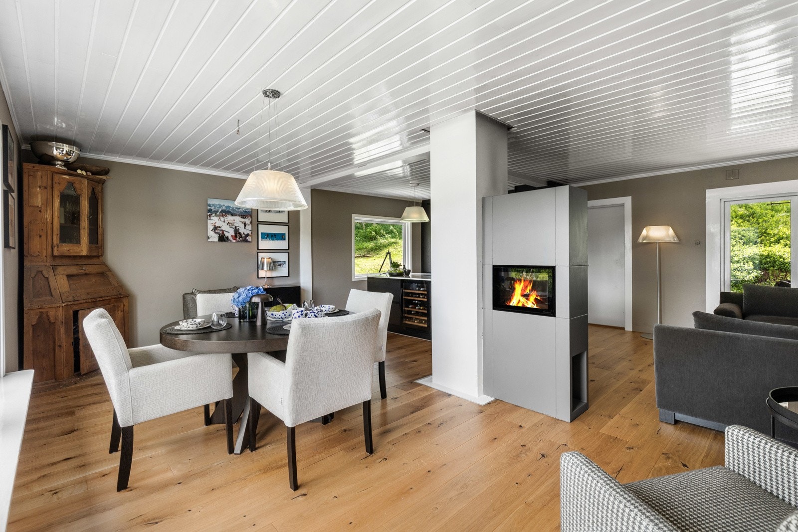Romslig stue med spiseplass, peis og store vinduer som gir naturlig lys. Galleribilde