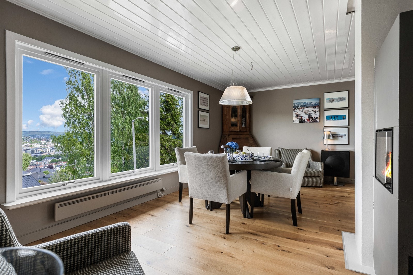 Lys og romslig stue med store vindusflater som fremhever den flotte utsikten over byen Galleribilde