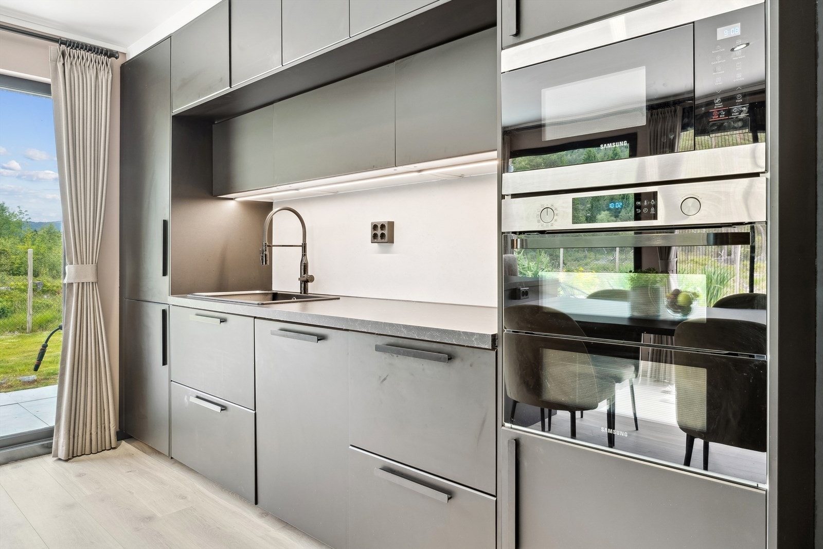 Det er kjøl/fryseskap, oppvaskmaskin, induksjonstopp, micro, stekeovn med dual cook og komfyrvakt på kjøkkenet Galleribilde