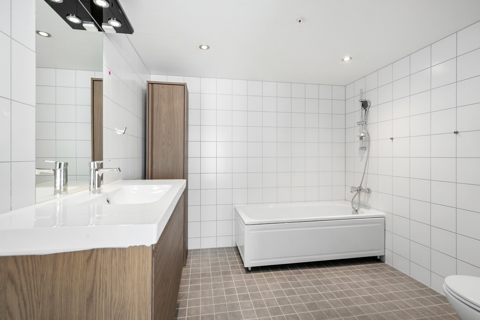 Bad tilknyttet hovedsoverommet har flislagte overflater, varmekabler i gulvet og downlightsbelysning i taket. Galleribilde