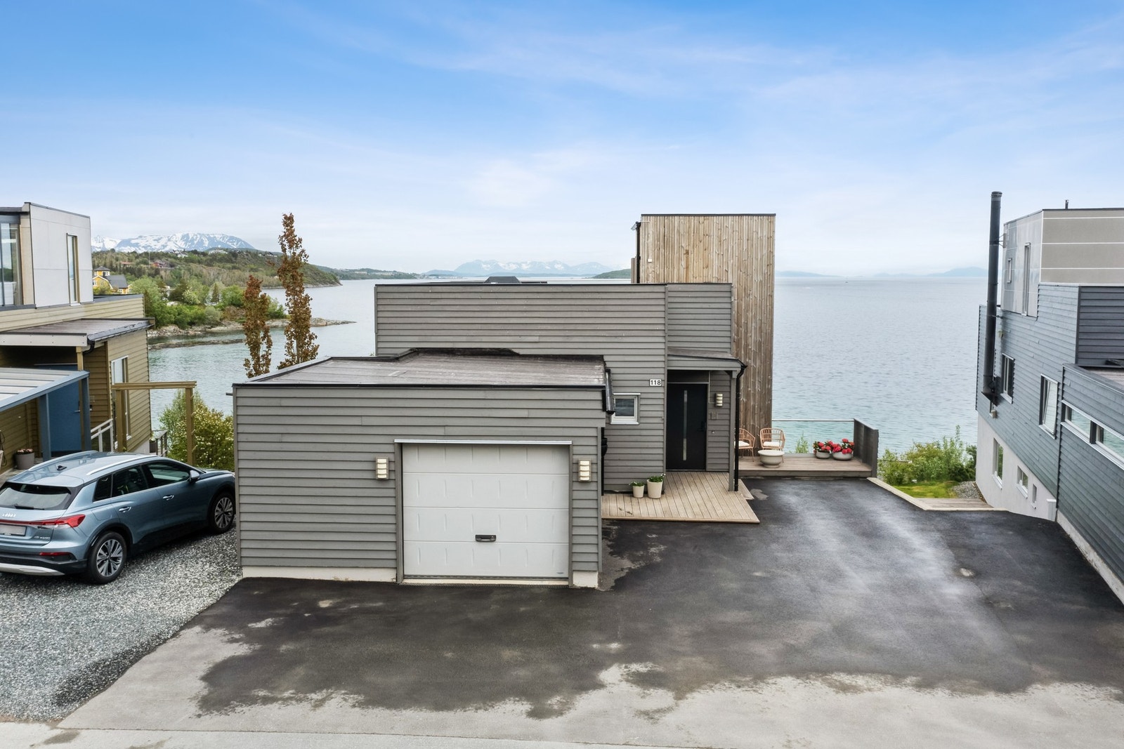 Slik ser eiendommen ut fra "baksiden". Garasje, asfaltert parkeringasareale og overbygd inngangsparti. Galleribilde