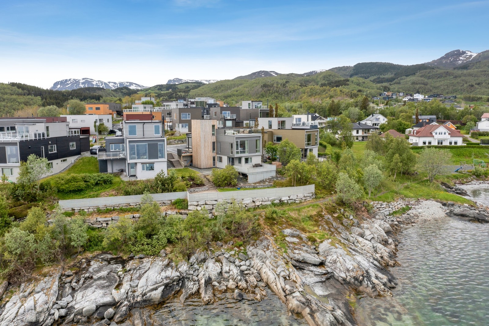 Pent opparbeidet eiendom med murer, busker og grøntarealer. Galleribilde