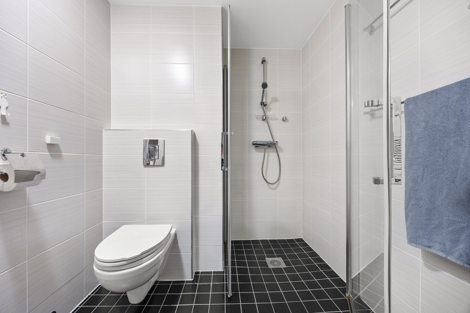 Baderommet har vegghengt toalett og dusj med glassdører for optimal plassutnyttelse. Galleribilde