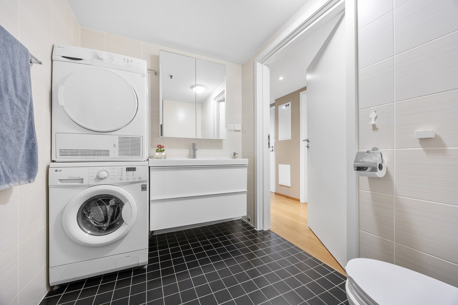 Praktisk vaskesone med plass til både vaskemaskin og tørketrommel på badet. Galleribilde
