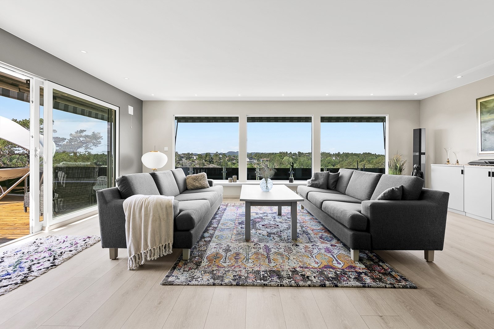 Store vinduer som slipper inn den deilige sola, og rammer inn den nydelige utsikten Galleribilde