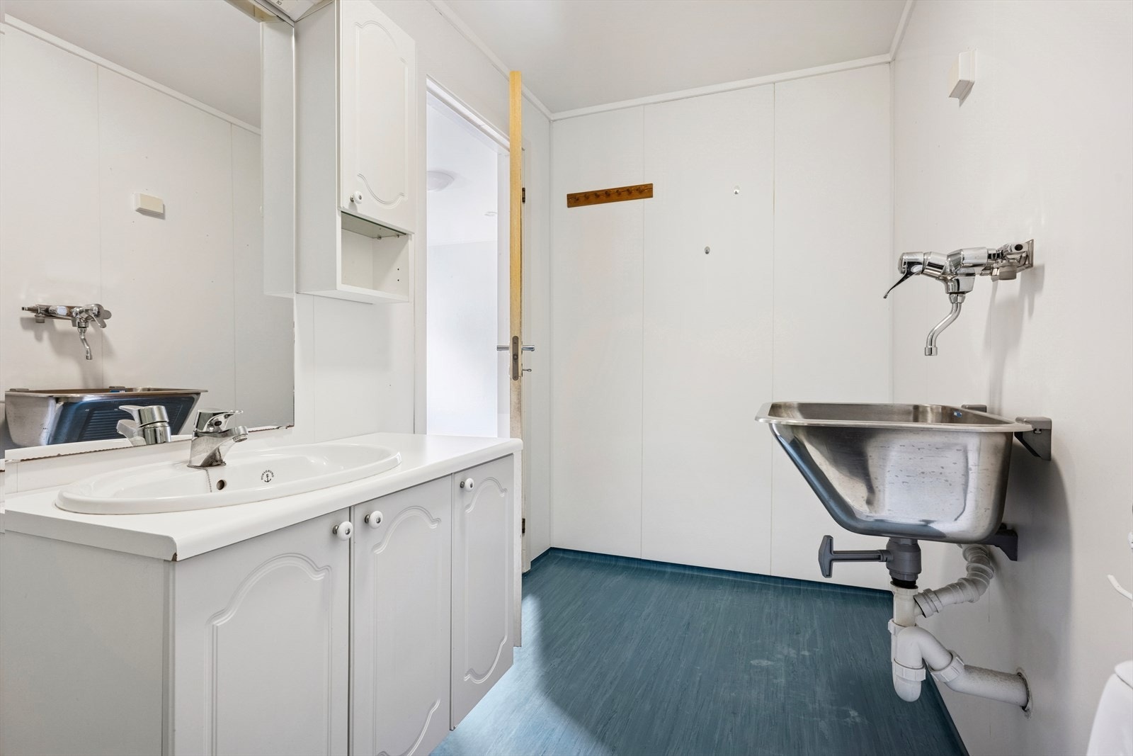 Baderommet er innredet med dusjkabinett, gulvstående toalett, og servant med skap. Galleribilde