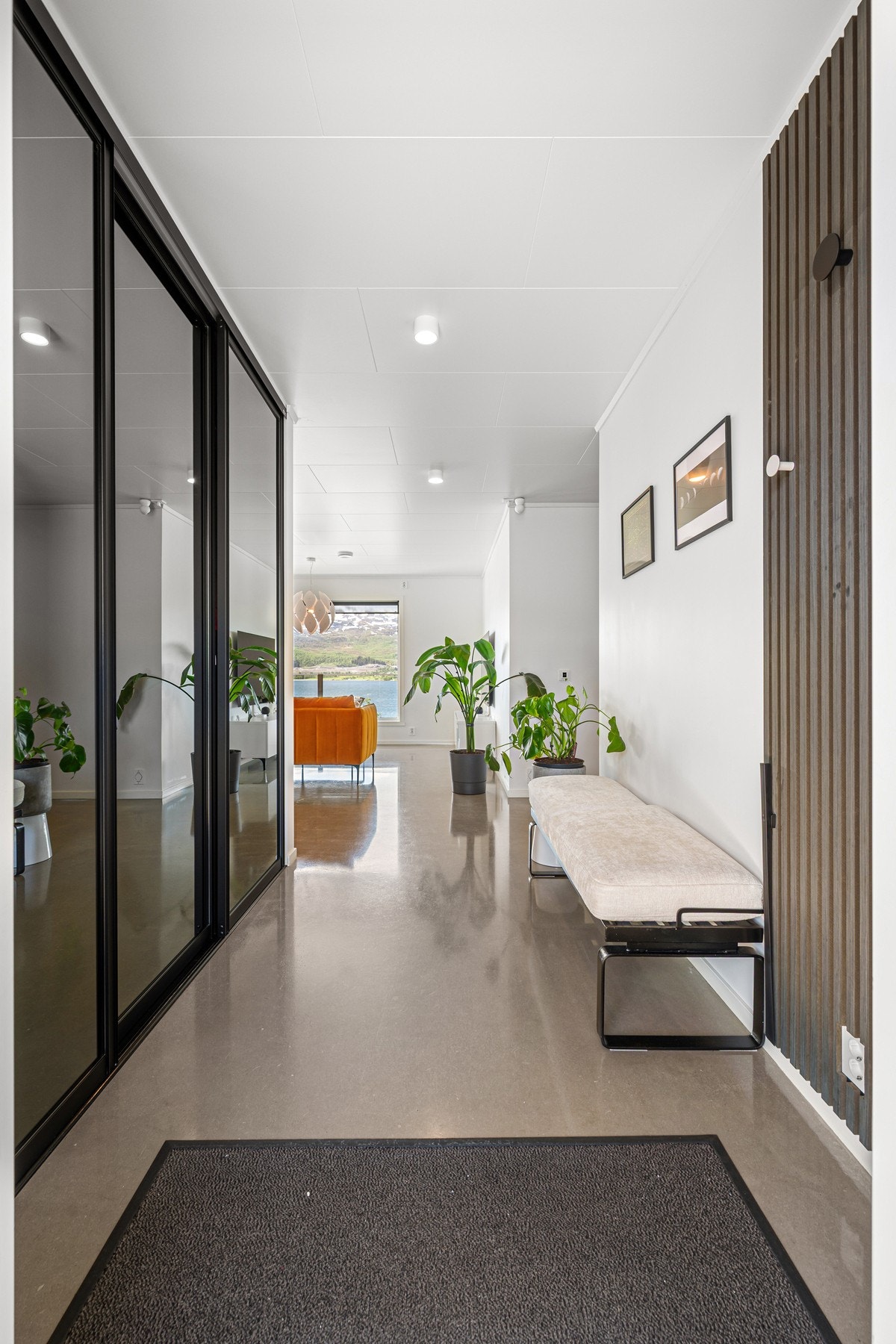 Åpen og romslig entré med stor innebygd skyvedørsgarderobe Galleribilde