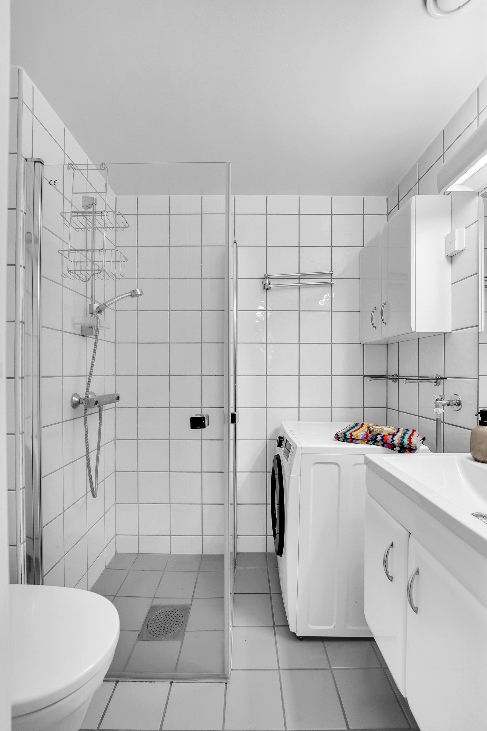 Bad med flislagte overflater og gulvarme. Badet ble modernisert i 2021 med ny innredning, dusjbatteri, toalett og garnityr. Opplegg for vaskemaskin. Galleribilde