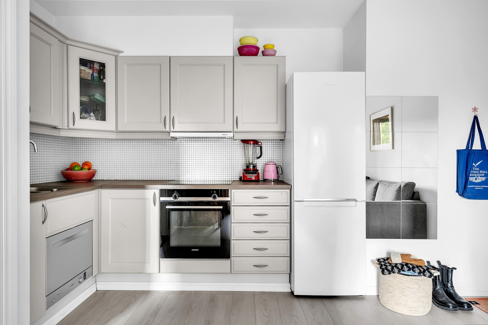 Kjøkkenet har innredning fra Huseby (2021) med profilerte eikefronter og laminat benkeplate med planlimt kum i rustfritt stål. Videre har innredningen mosaikkfliser på vegg over benkeskap og belysning under overskap. Galleribilde