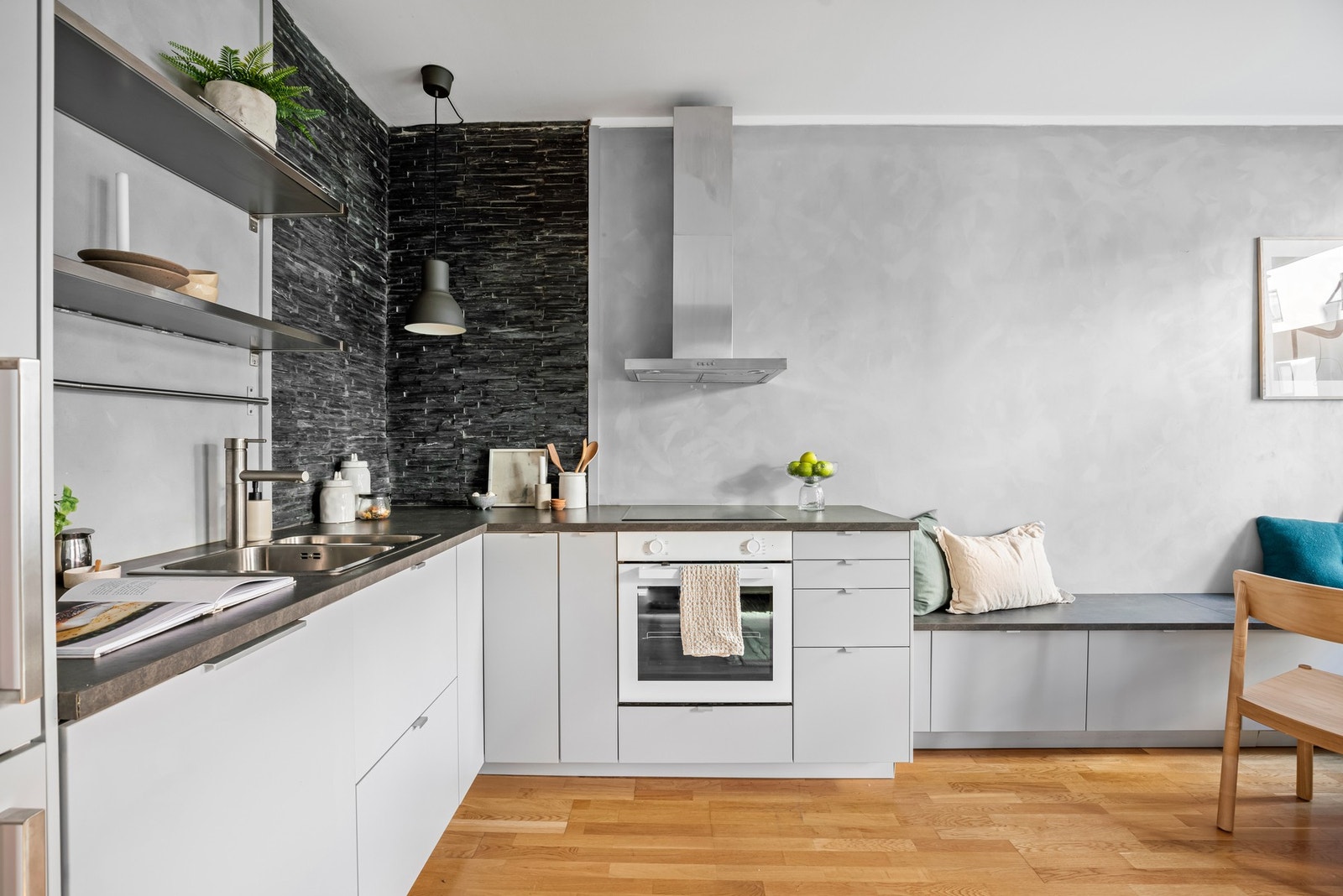 Kjøkkenet har tidløs innredning fra IKEA. Benkeplaten er i laminat og står fint til den grå skiferveggen langs pipeløpet i hjørnet. Galleribilde