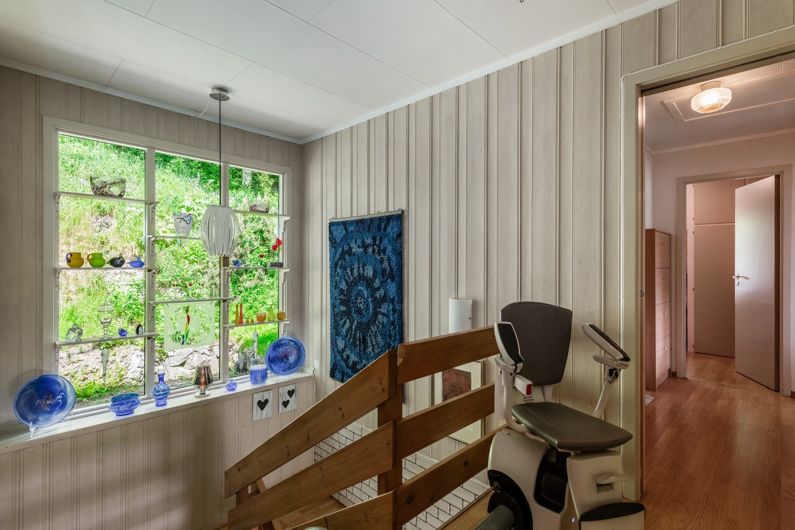 Store vindusflater ned trappen, med naturen tett på Galleribilde