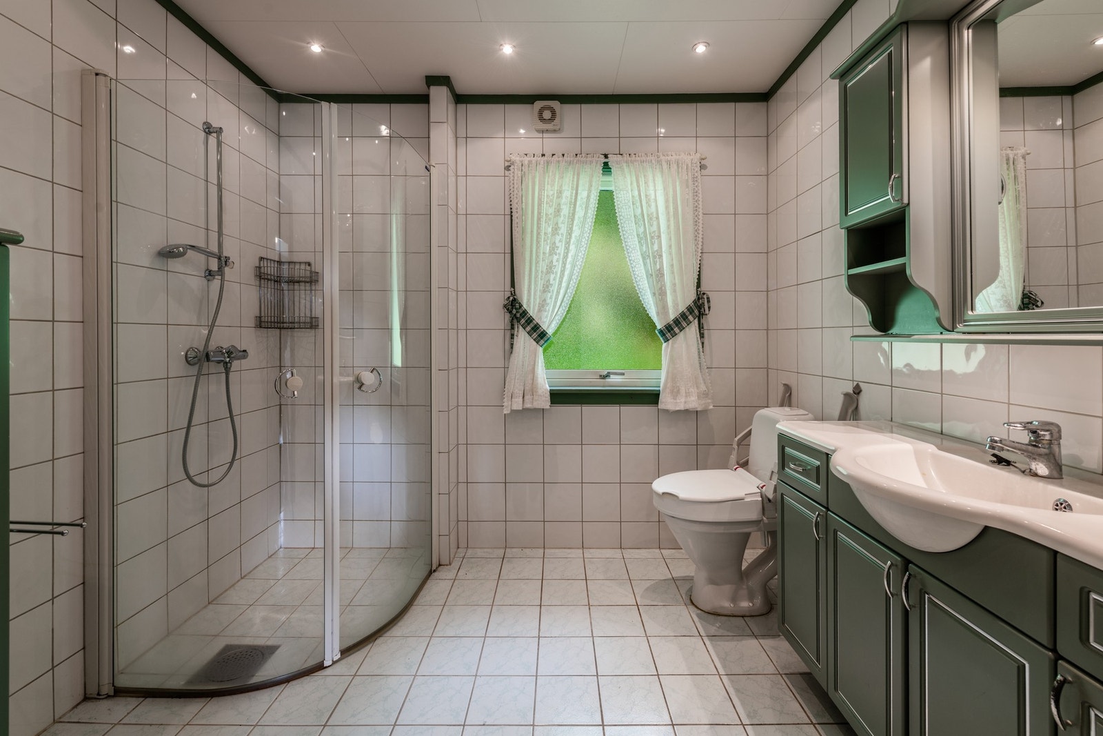 Badet i 1. etasje er flislagt med stor dusj Galleribilde