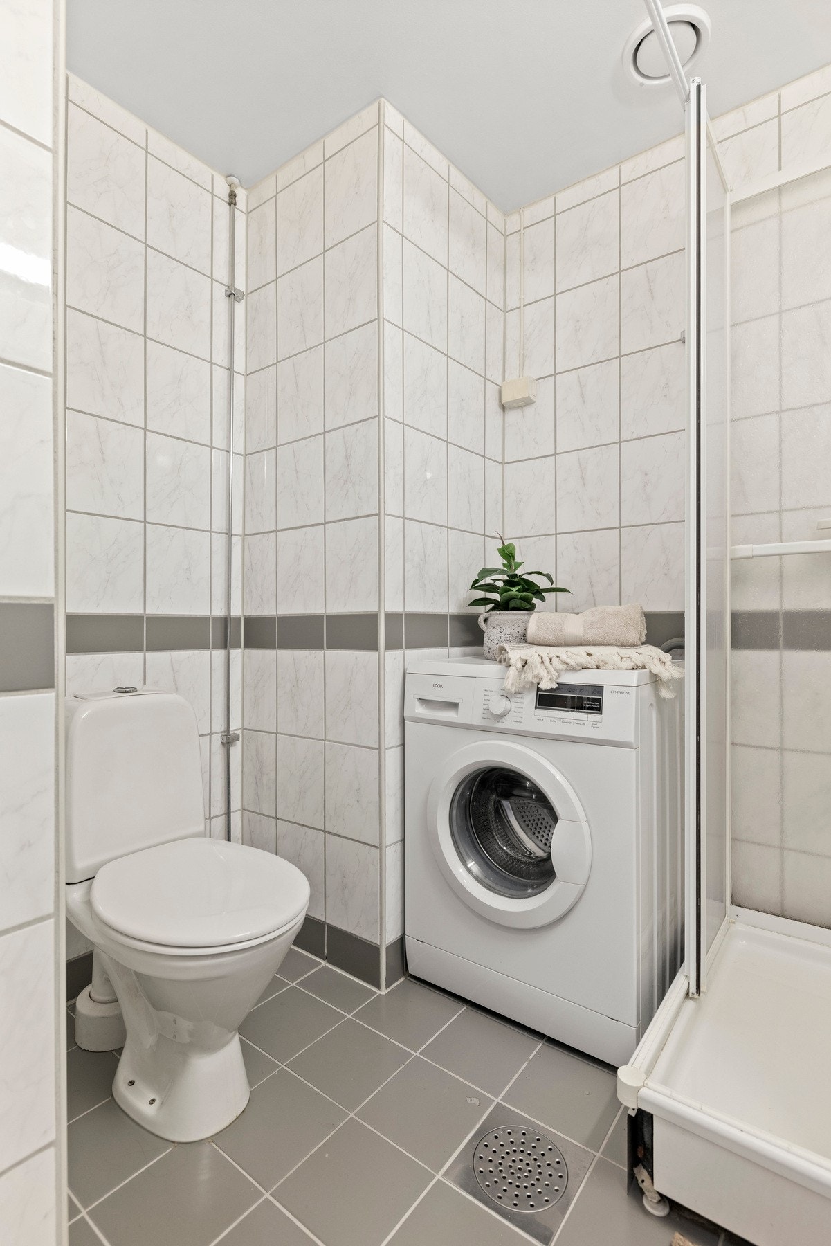 Pent, flislagt bad med opplegg for vaskemaskin og gulvvarme. Galleribilde