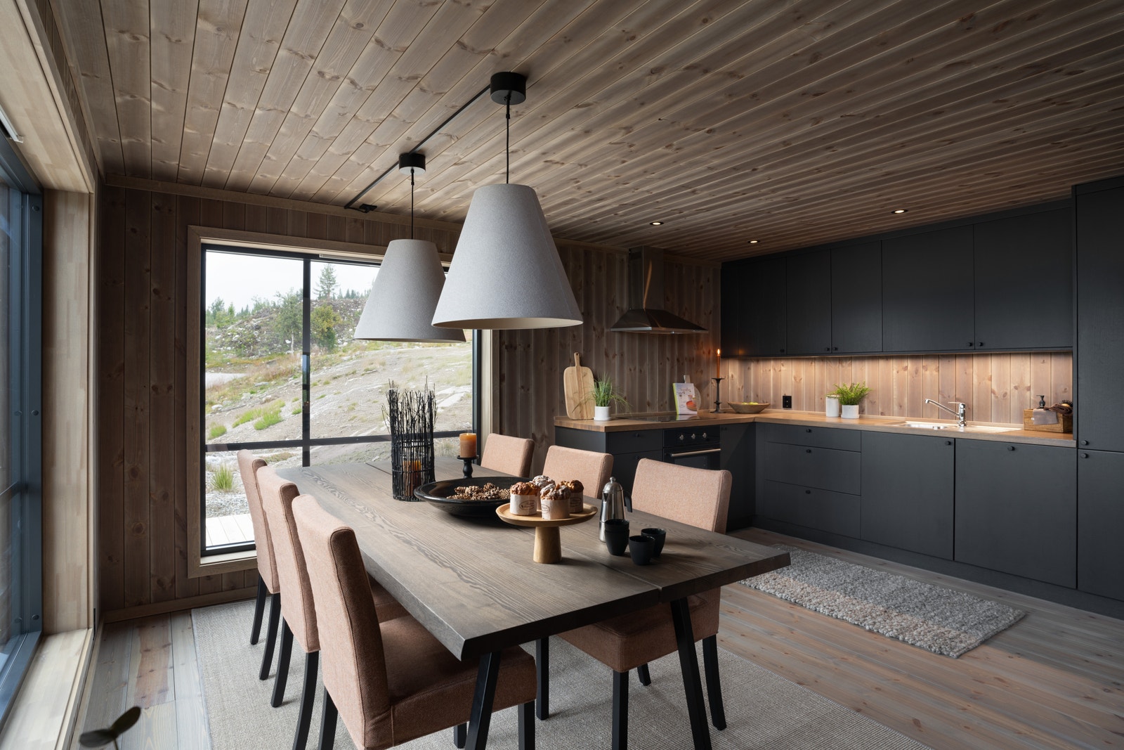 Et sosialt oppholdsrom med åpen stue- og kjøkkenløsning Galleribilde