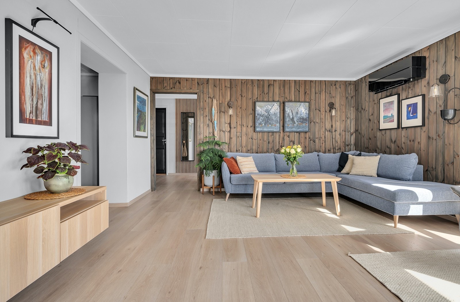 Hovedetasjen har en romslig stue med laminat på gulvene og delvis malte plater/panel Galleribilde