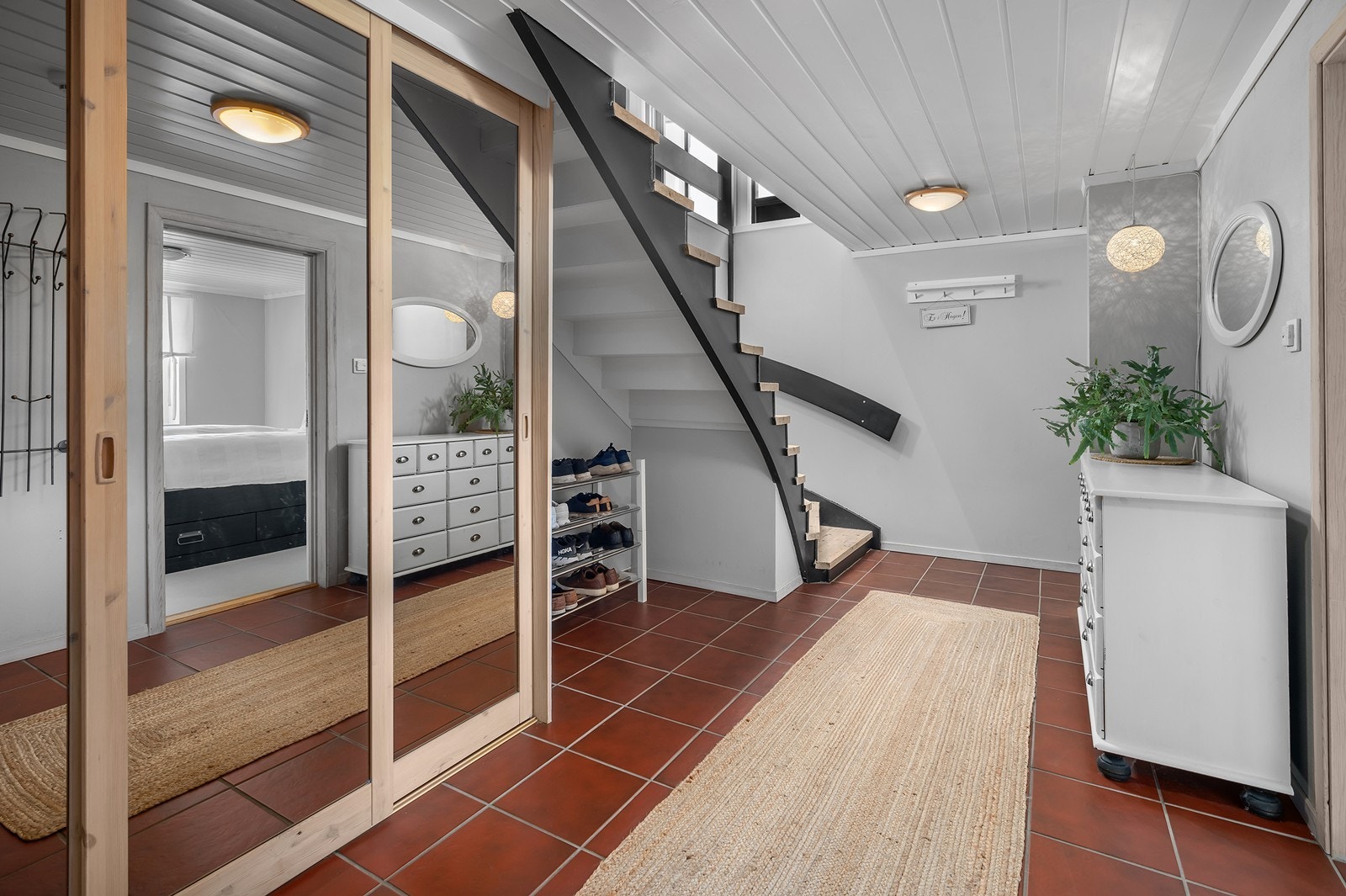 I gangen er det skyvedørsgarderobe for yttertøy og plass til å sette fra seg skoene under trappen Galleribilde