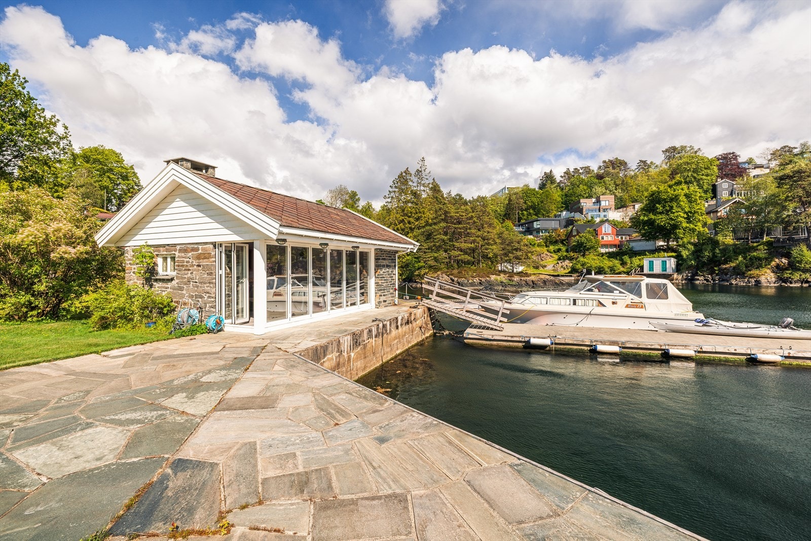 Idyllisk badehus med store glassflater og flott bryggeanlegg, perfekt for båtentusiasten. Eiendommen ligger lunt til i en rolig bukt. Galleribilde