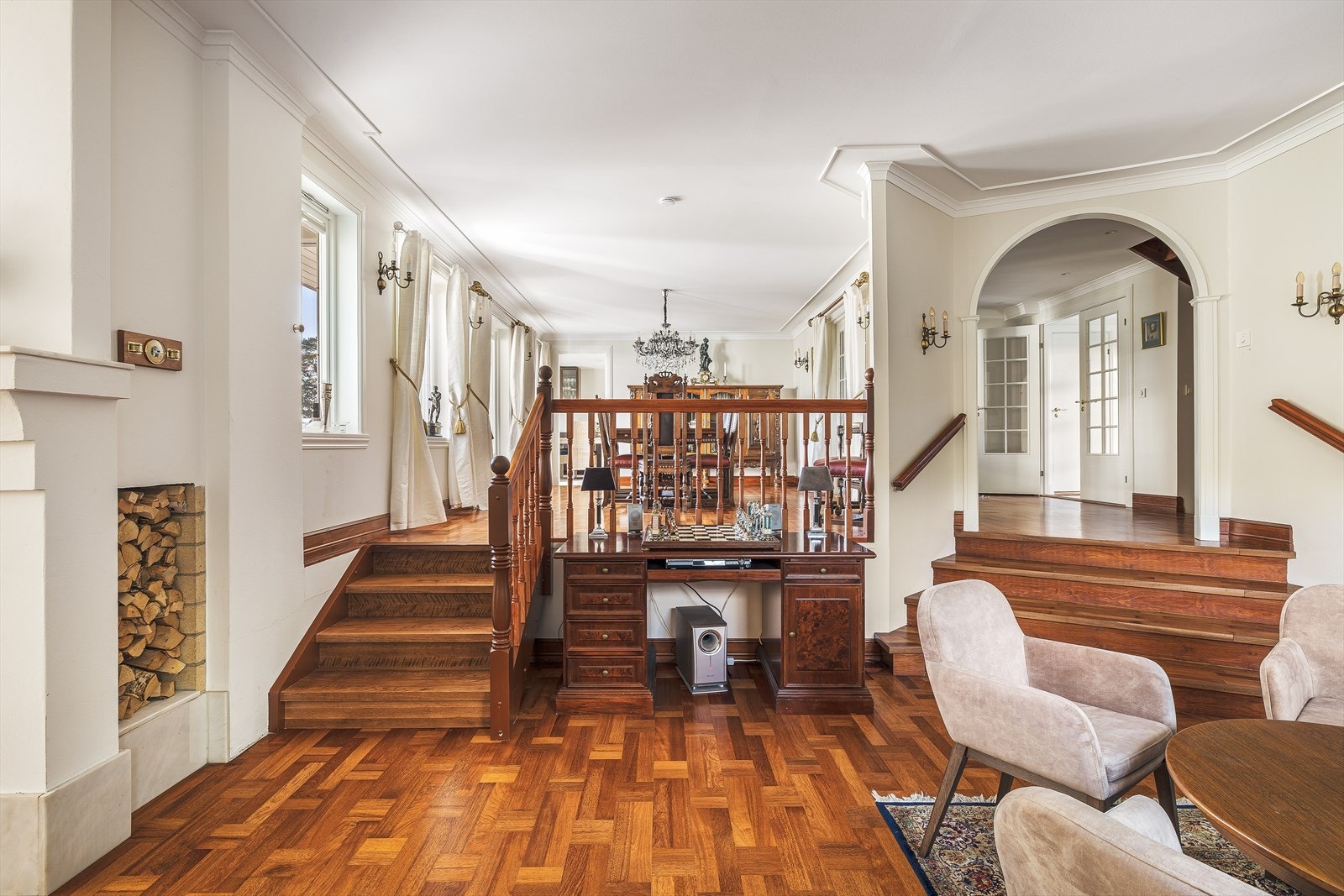 Elegant oppholdsrom med vakker stavparkett i heltre eik, som gir en varm og tidløs atmosfære. De ulike nivåene i rommet skaper en spennende romfølelse, og den klassiske innredningen understreker den gjennomførte og stilfulle karakteren. Galleribilde