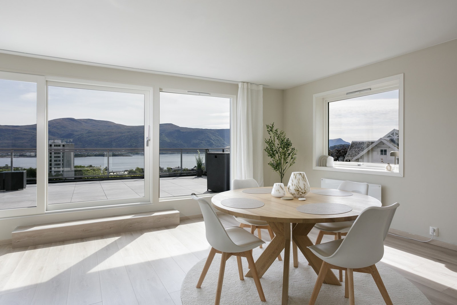 Spisestuen er plassert ved vindu og det er godt med lysinnslipp og flott utsikt mot fjord og fjell Galleribilde