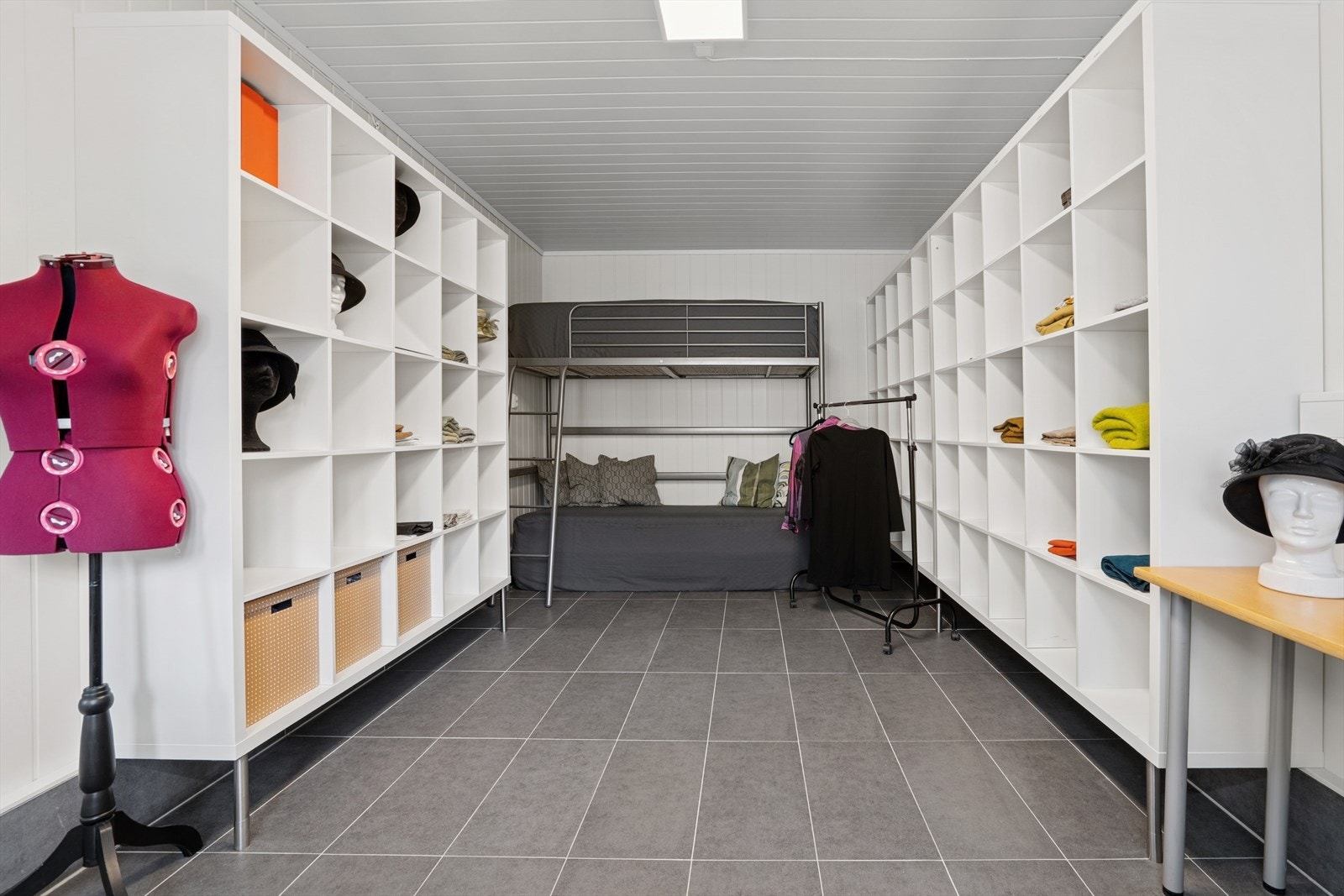 Innredet rom i bakkant av dobbel garasjen. Innvendige vegger og himling er kledd med malte plater og panel. Gulver har fliser med elektriske varmekabler. Galleribilde