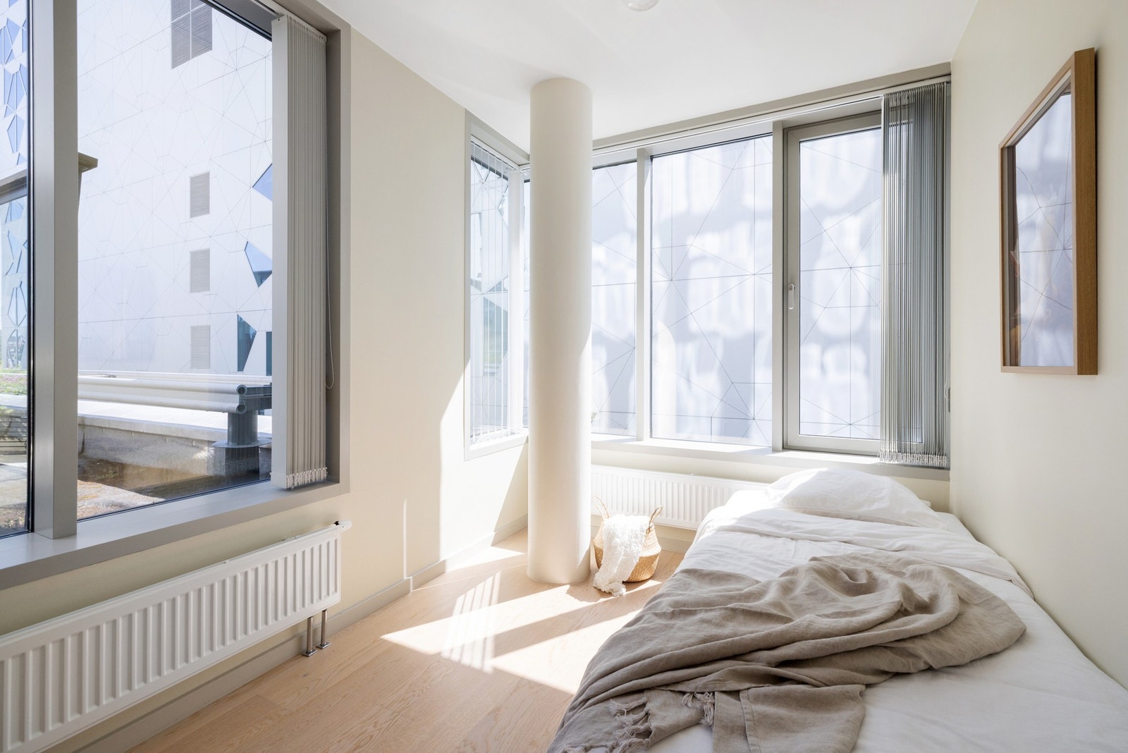 Et delikat soverom med store vindusflater som slipper rikelig med dagslys inn fra flere vinkler. Galleribilde