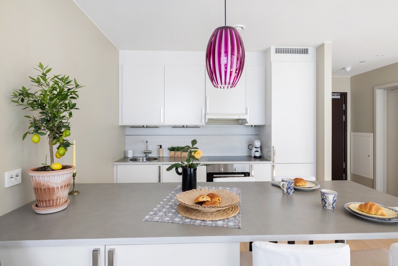 Kjøkkenet har et tidløst utseende med hvite slette fronter og benkeplate i laminat. Galleribilde