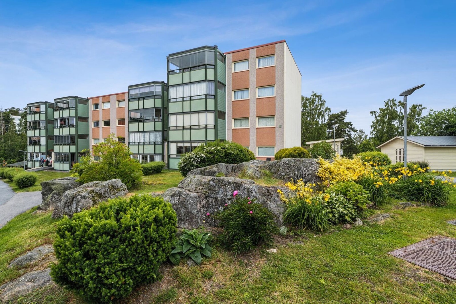 Borettslaget har en pent opparbeidet tomt med grønt områder og asfalterte veier Galleribilde