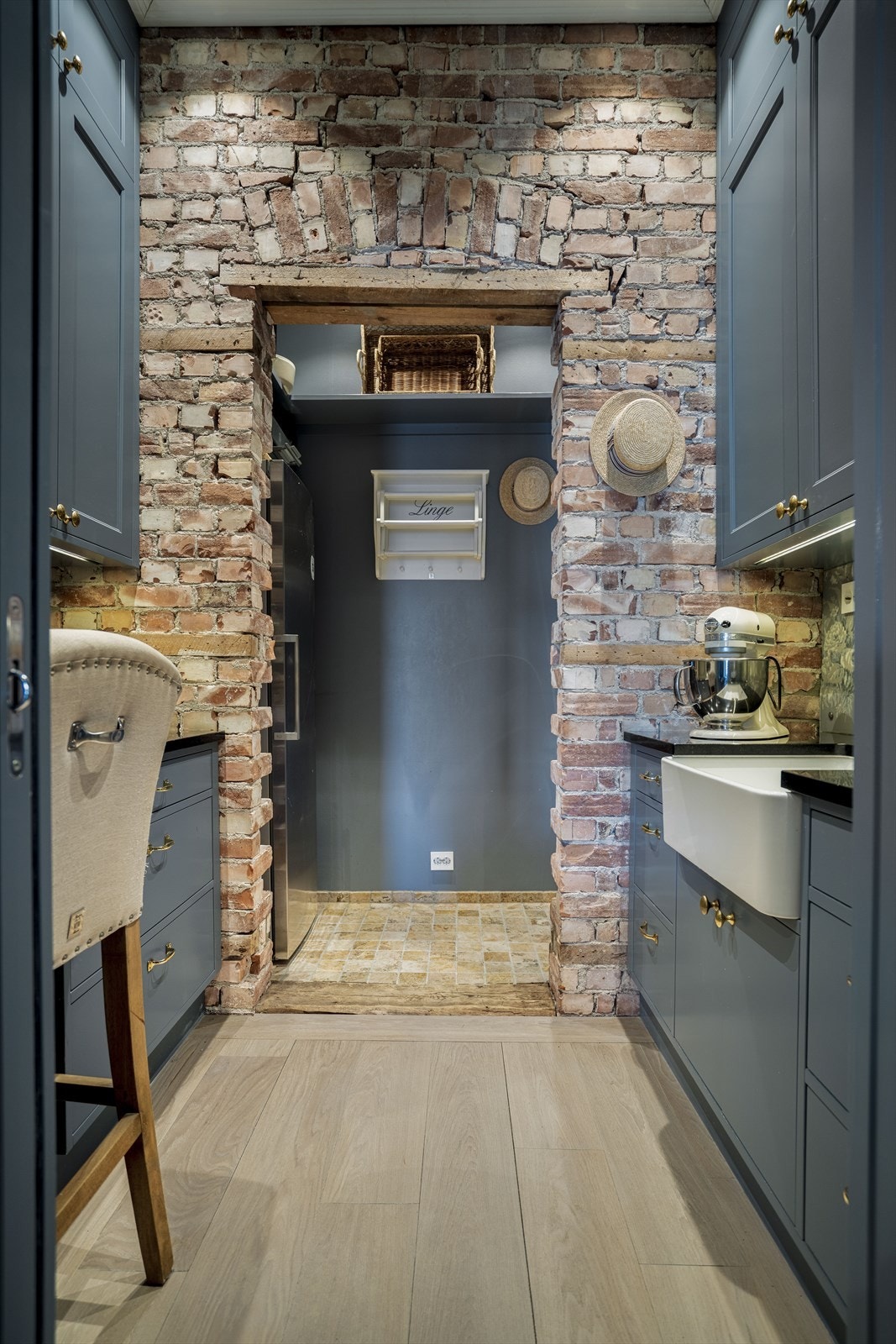 Svært praktisk løsning med spiskammers/ grovkjøkken med adkomst gjennom skyvedør fra kjøkkenet. Flott originalvegg som har eksponert teglstein. Galleribilde