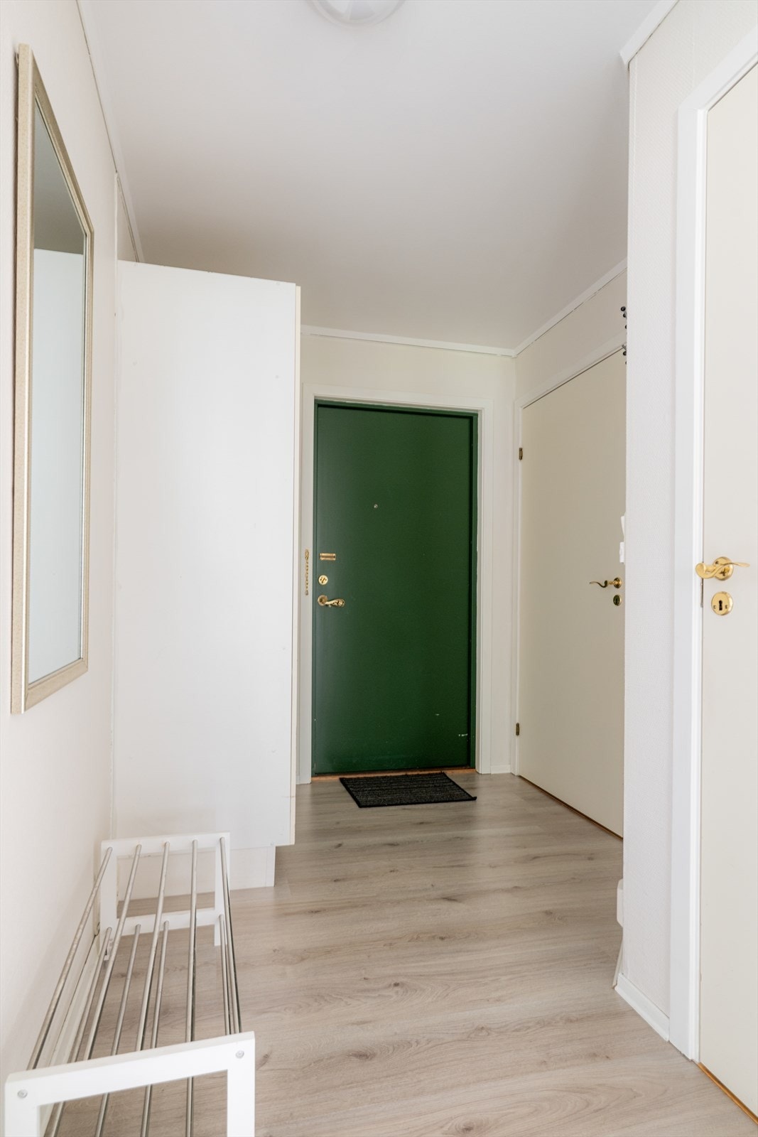 Velkommen inn i en hyggelig entré med praktisk garderobeskap. Her er det lagt laminat på gulvet, mdf-panel på veggene og malt, pusset betong i taket. Galleribilde