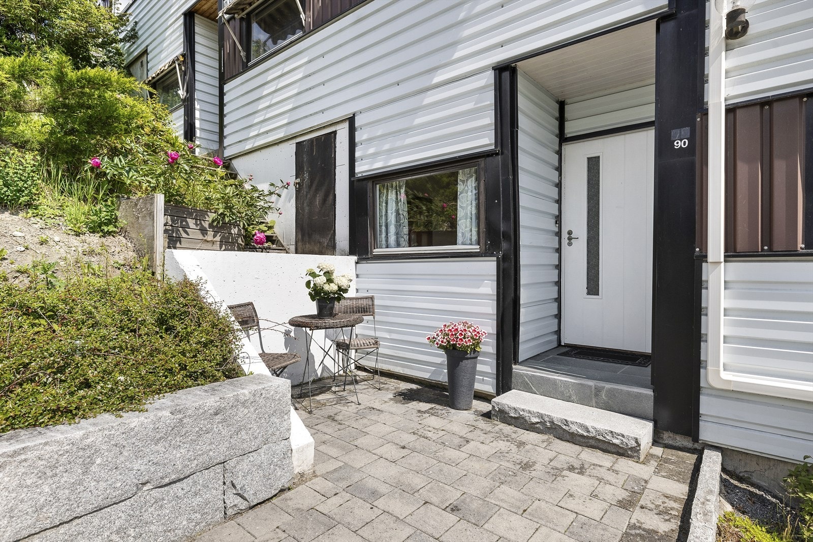 Hyggelig sitteplass utenfor inngangspartiet. Pent opparbeidet med belegningsstein. Galleribilde