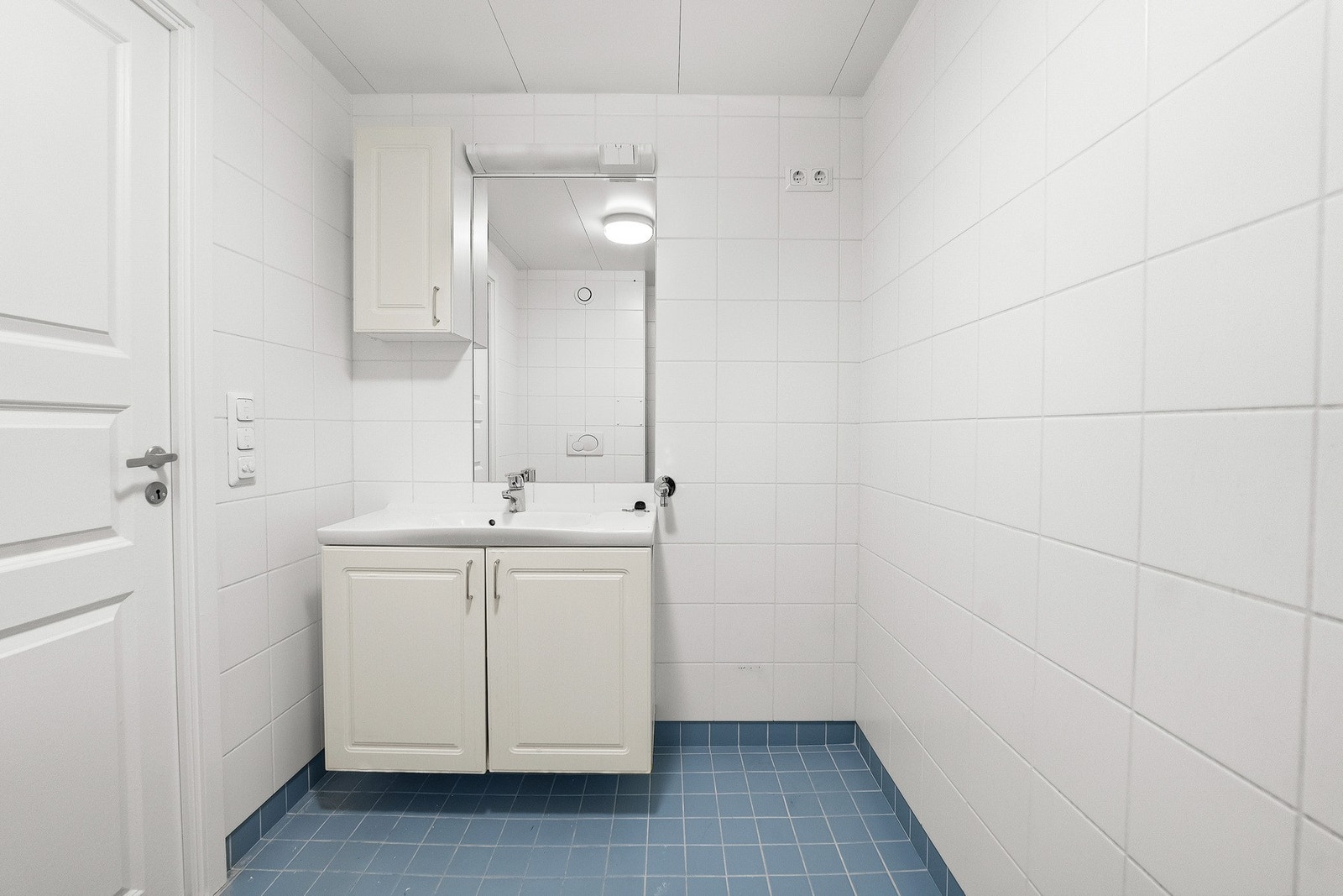 Innredning med underskap og speil med lys, samt opplegg for vaskemaskin. Galleribilde