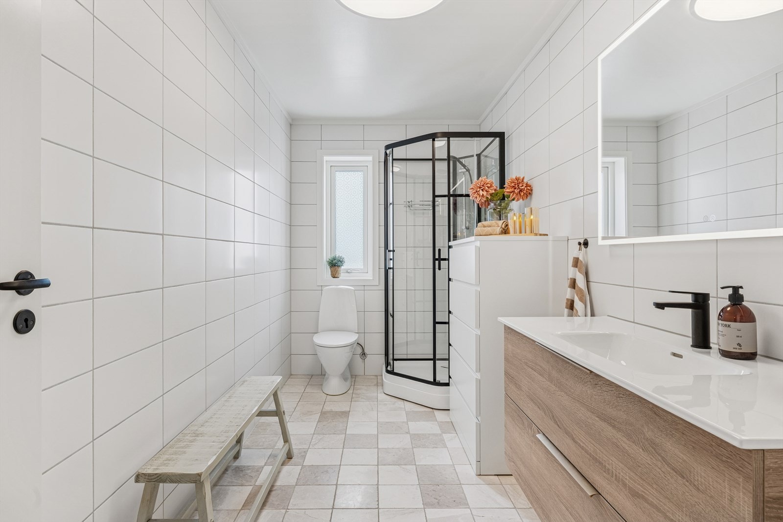 Romslig baderom i 1. etasjen med flislagte overflater, dusjkabinett (fra 2022), toalett og servant med god oppbevaringsplass Galleribilde