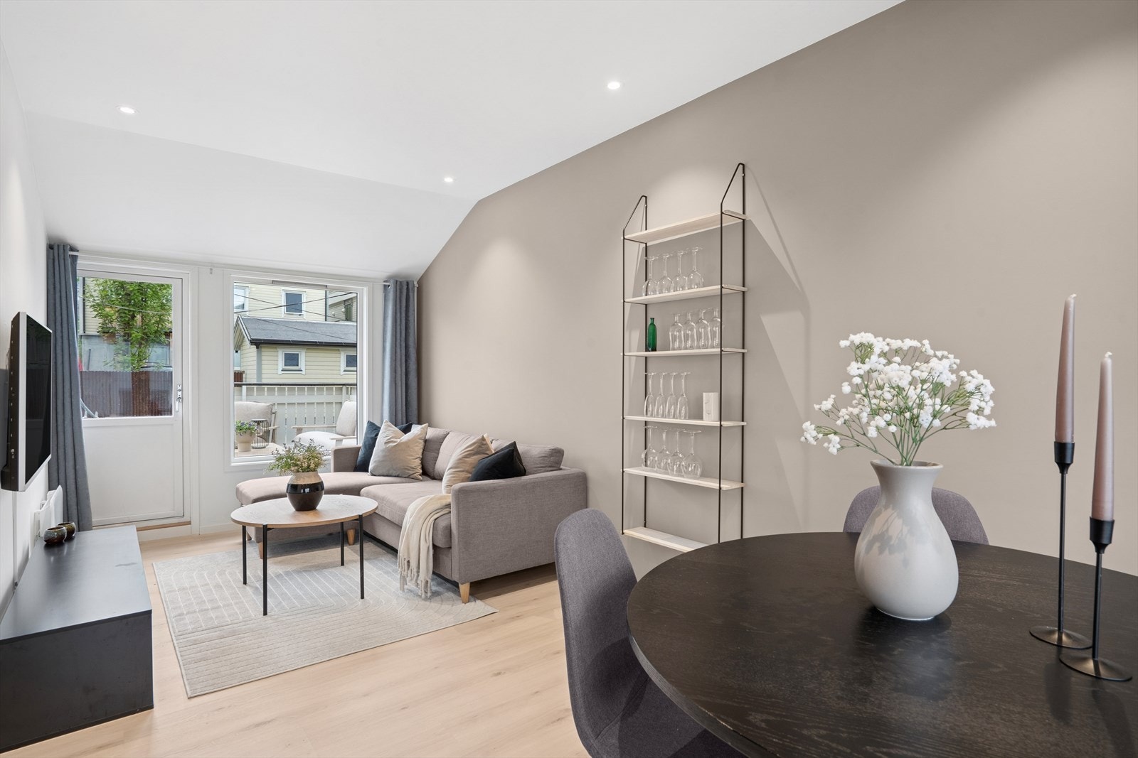 En moderne og flott stue med lyse, listefrie overflater og downlights i tak Galleribilde