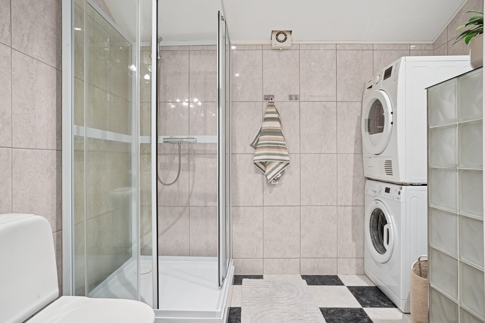 Badet er flislagt og utstyrt med dusjkabinett. Opplegg for både vaskemasking og tørketrommel Galleribilde