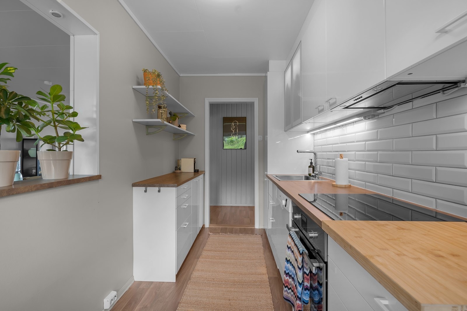 Innredning med glatte fronter. Benkeplaten er av laminat. Integrert kjøl/fryseskap, oppvaskmaskin, platetopp og stekeovn. Galleribilde