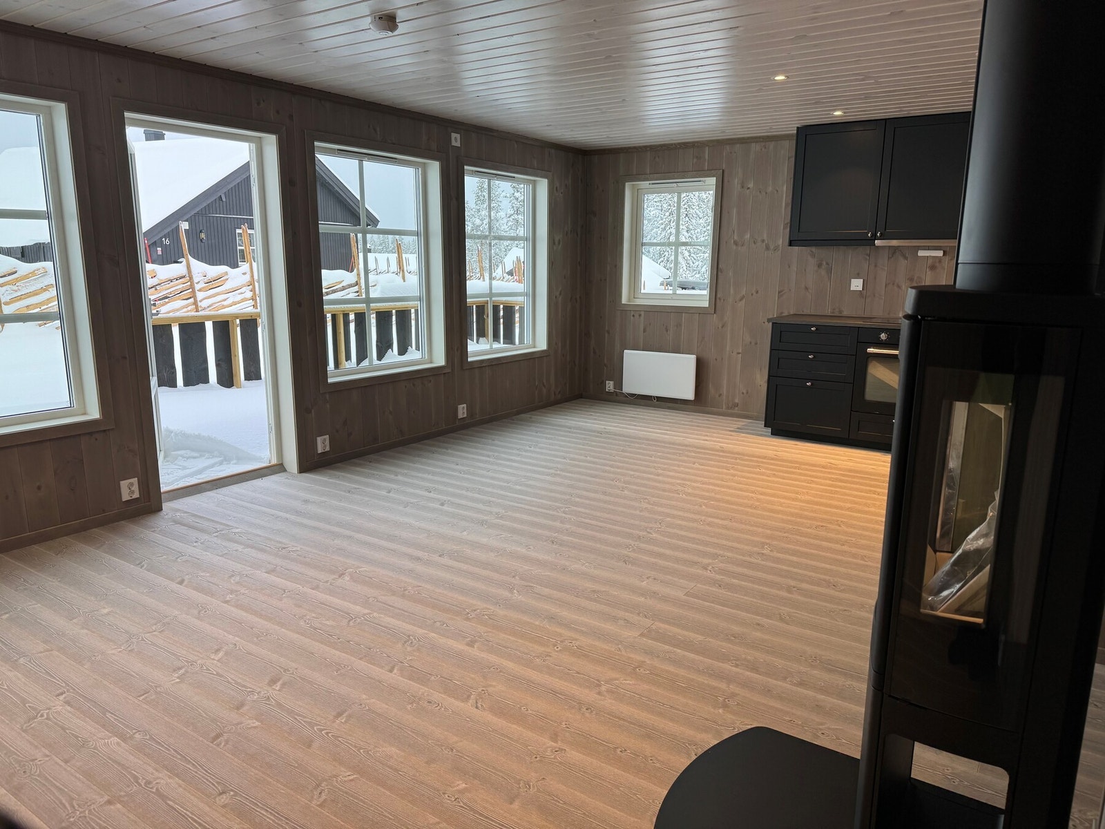 Hytta byr på en lys og luftig stue i åpen løsning med kjøkken, og en stemningsfull peis som naturlig samlingspunkt. Bilde er kun ment som illustrasjon, og er ikke av aktuell hytte. Galleribilde