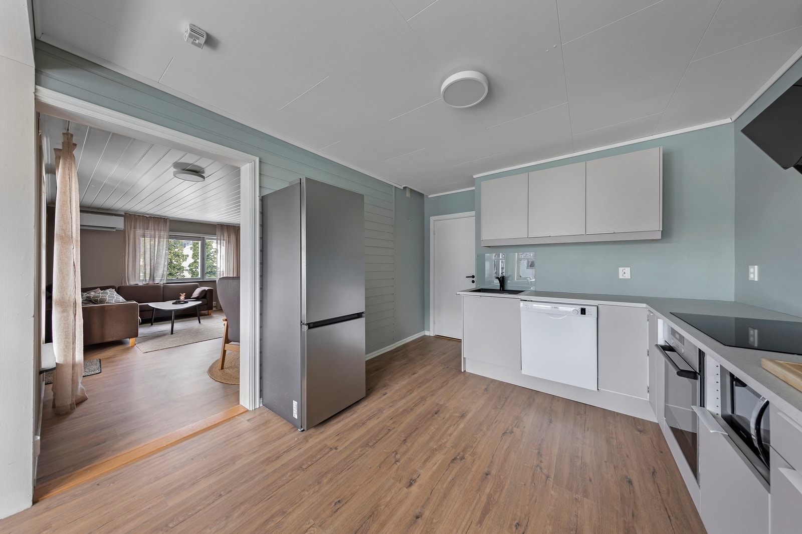 Kjøkkenet er delvis nytt i 2024 og har malte, glatte fronter og benkeplate i laminat. Det er brukt opp igjen noen skrog fra det gamle kjøkkenet Galleribilde