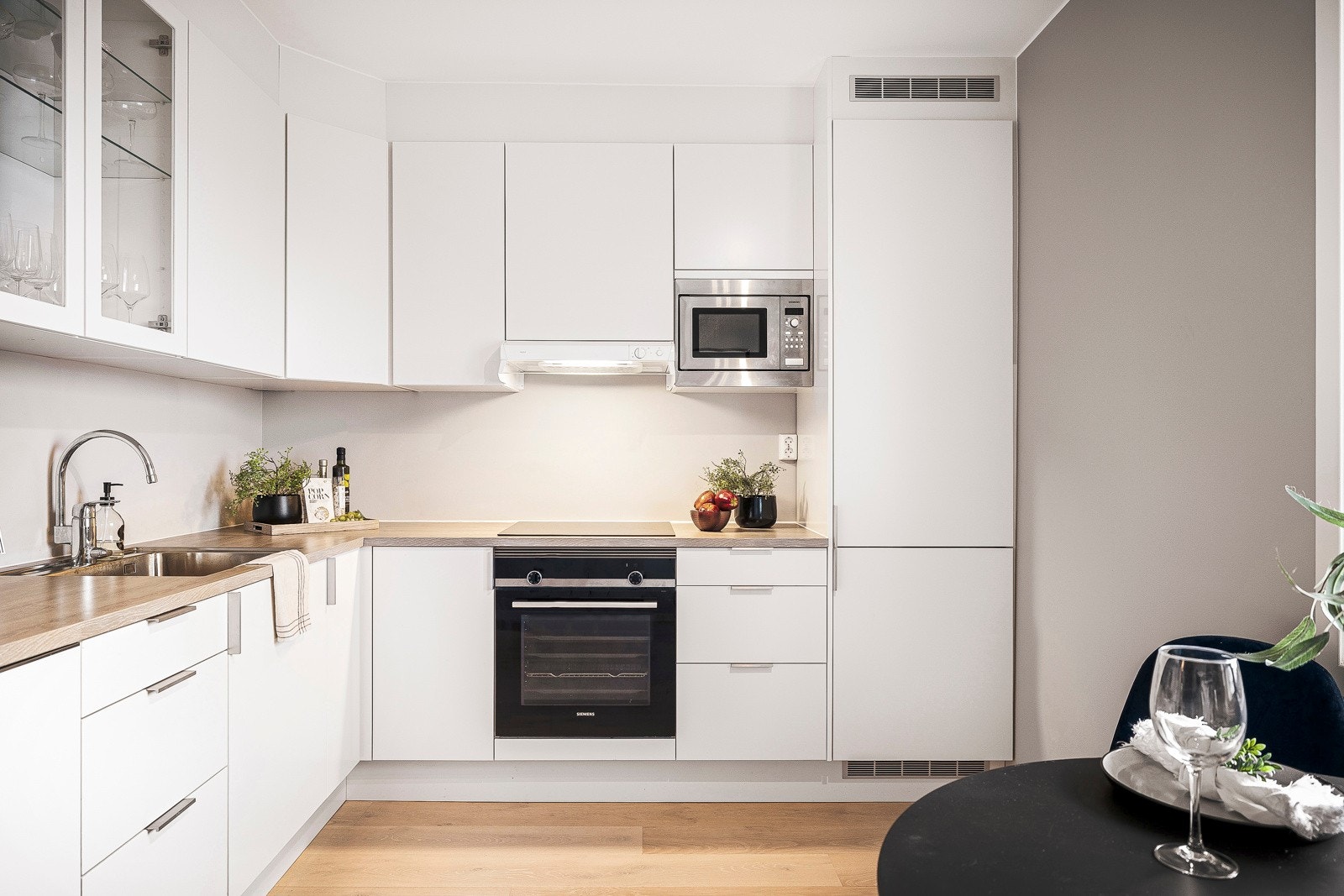 - Kjøkkenet har innredning av slette, lyse fronter og laminert benkeplate med stålbeslag - Galleribilde