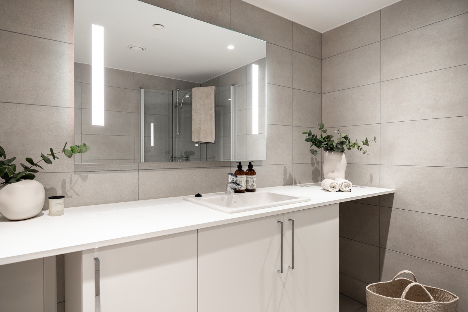 Baderomsinnredning bestående av benkeskap med glatte fronter. Galleribilde