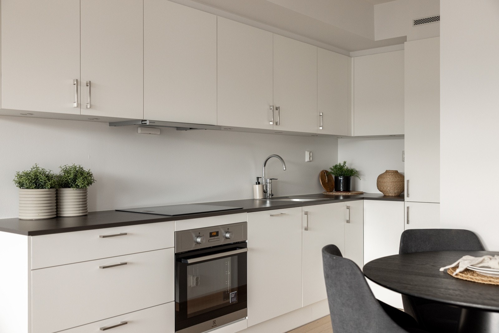 Kjøkkenet har ubrukte hvitevarer integrert i innredningen; induksjonstopp, varmluftsovn, oppvaskmaskin og kjøl/frys. Galleribilde