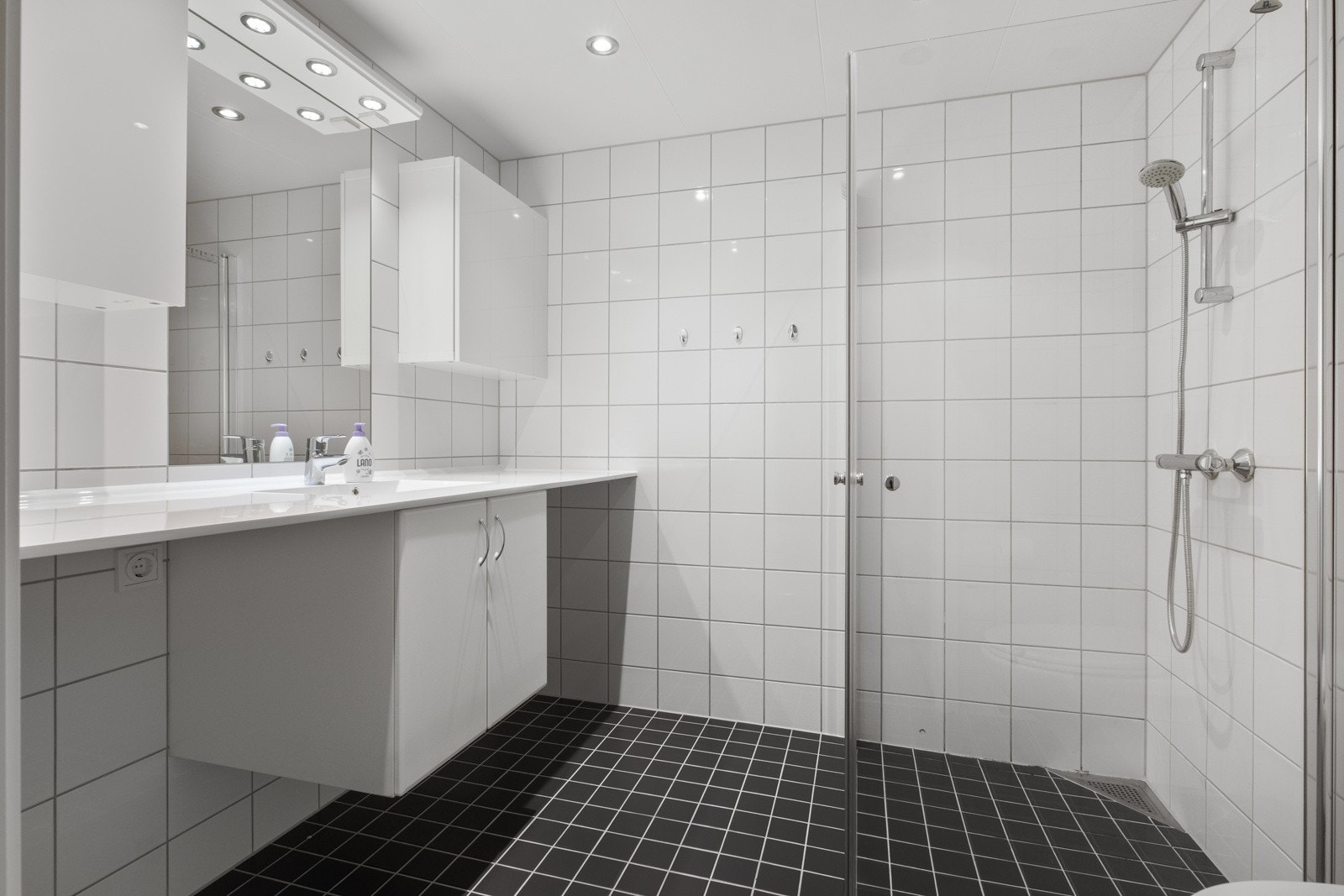 Baderom med opplegg for vaskemaskin og tørketrommel under benk. Galleribilde