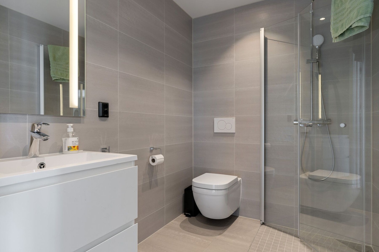 Badet i 1. etasje er utstyrt med baderomsinnredning, dusjhjørne og toalett Galleribilde