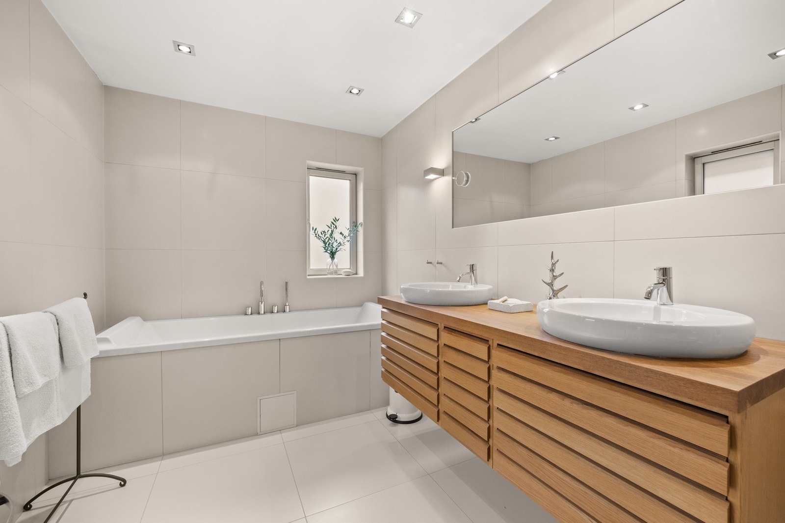 Badet har badekar, dusjhjørne, vegghengt toalett og dobbel servant. Innredning fra Unoform. Galleribilde