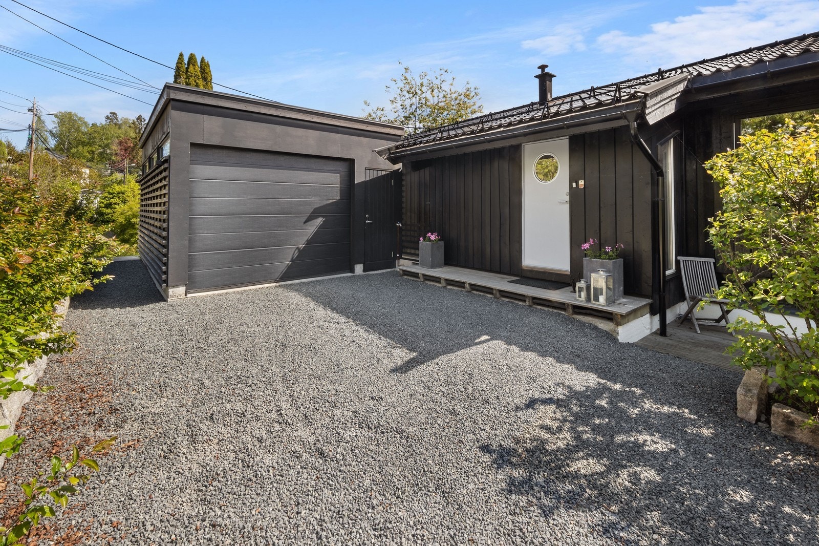 Gårdsplassen med garasjen og inngangsparti. Galleribilde