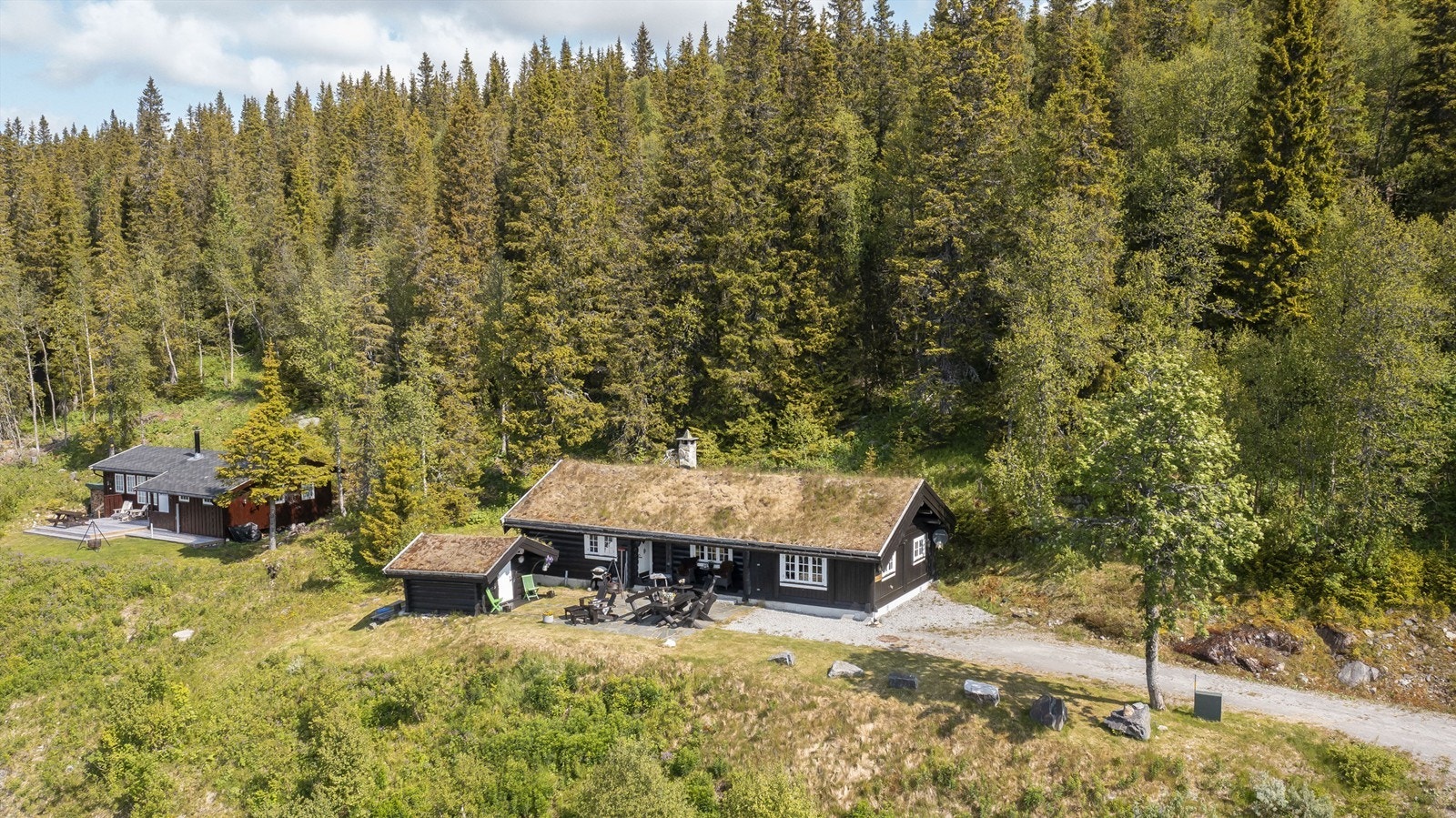 Klassisk hytte med torv på tak, laftet tømmer og skiferbelagt uteområde Galleribilde