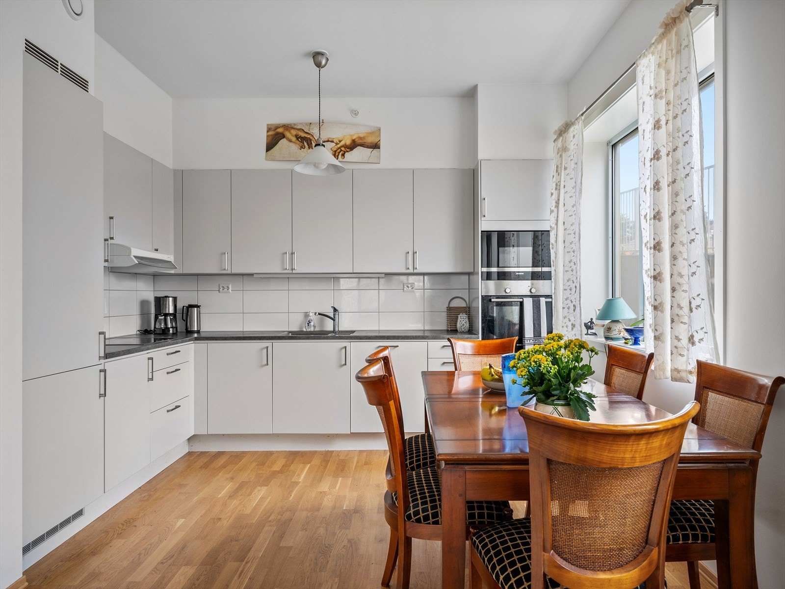 Lys og romslig kjøkken med moderne innredning, store vinduer og plass til spisebord. Perfekt for hyggelige måltider og samvær. Galleribilde