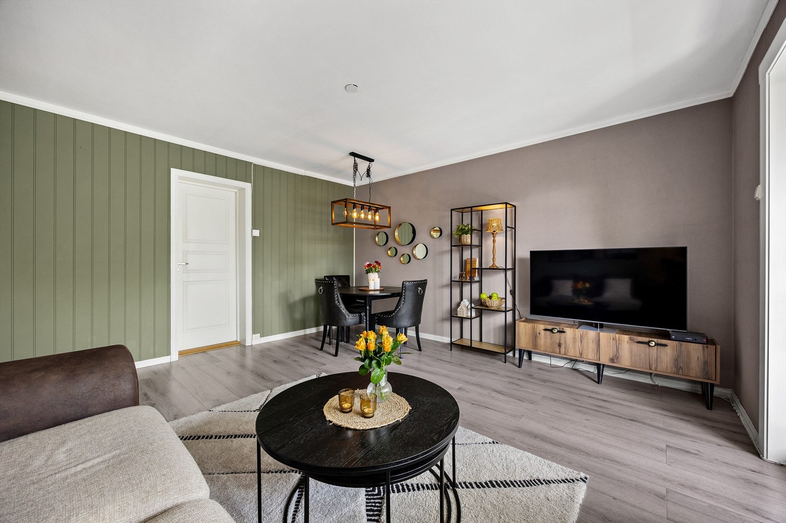 Oppholdsrommet gir plass til sofa, TV og spisebord. Galleribilde